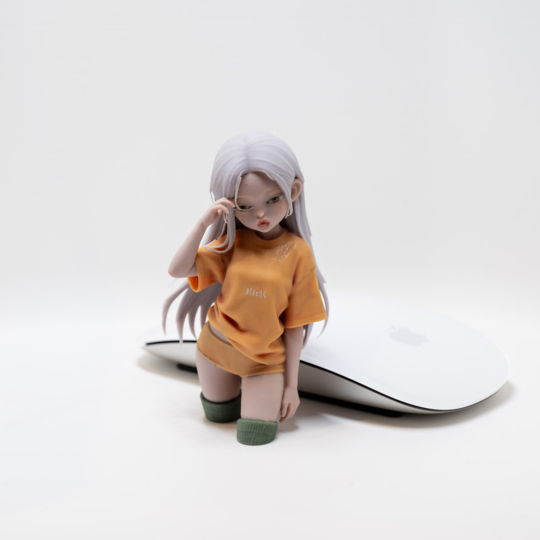 Full-color kneeling girl print next to a computer mouse for scale