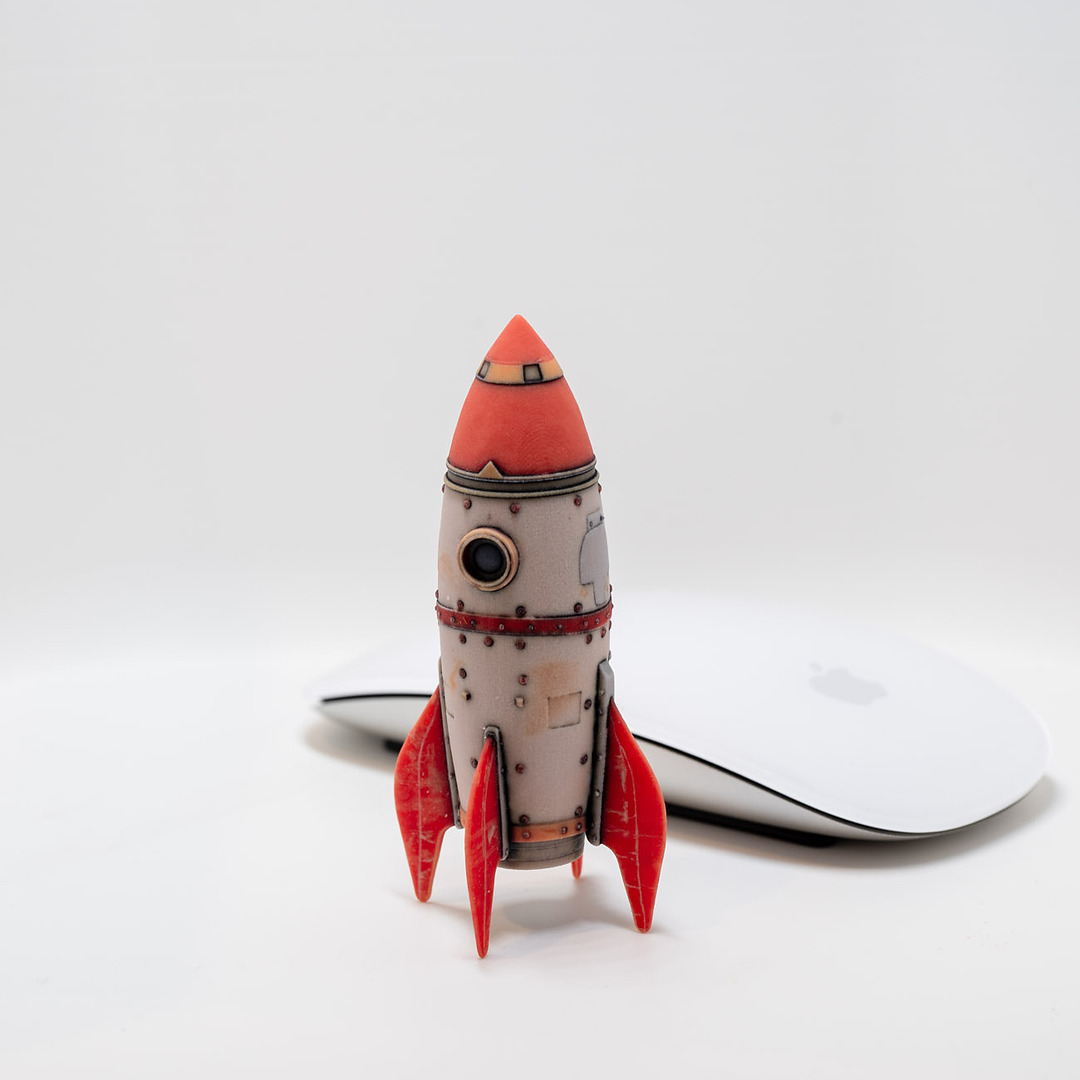 Full-color retro rocket print next to a computer mouse for scale